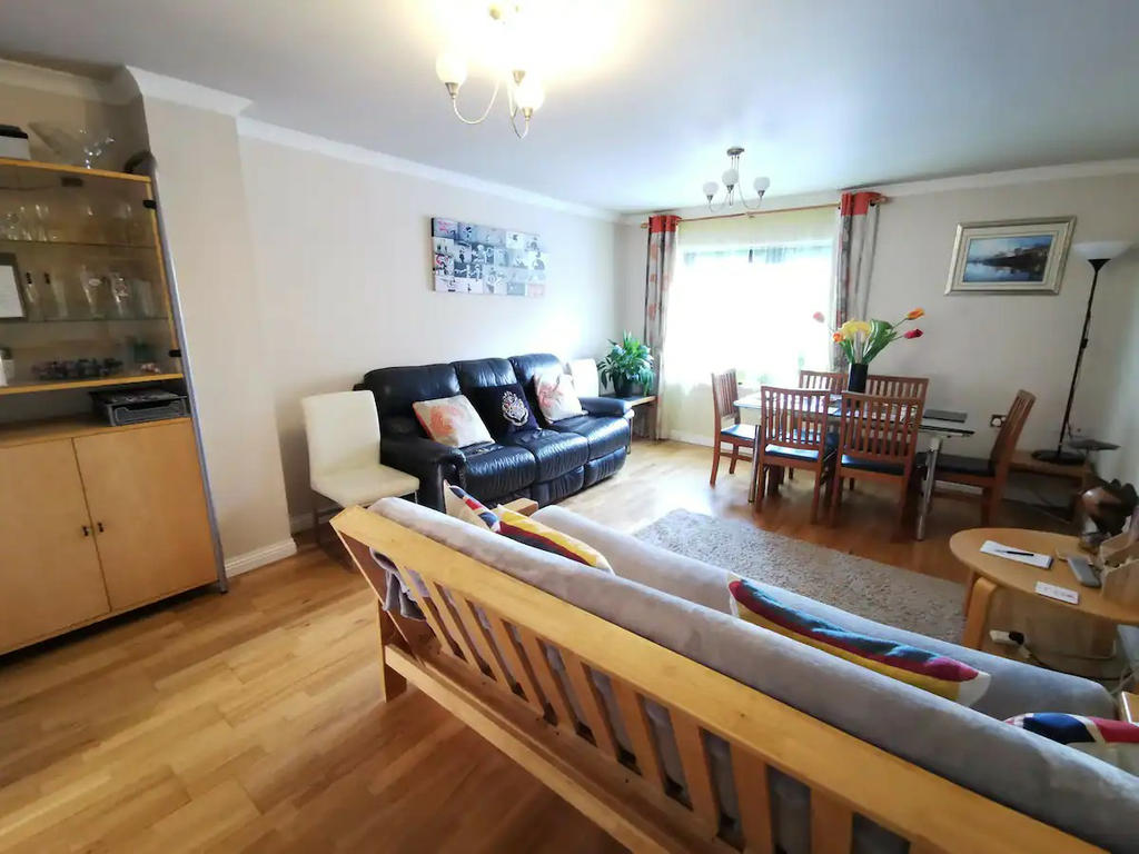 Large living room with 2 sofas and a dining table, open view towards Meadowbank church