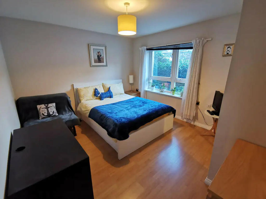 Double bedroom 1 with mirrored wardrobe, bedside cabinet, chest of drawers, TV and a small sofa