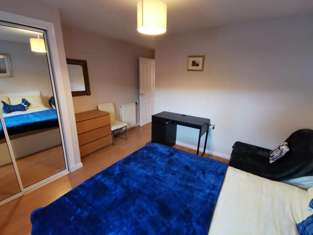 Double bedroom 1 with mirrored wardrobe, bedside cabinet, chest of drawers, TV and a small sofa