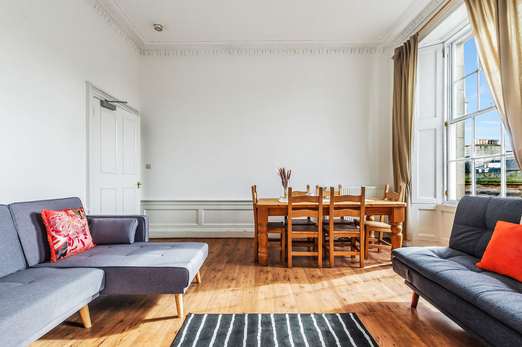 Bright living room with 2 sofa beds, fireplace and dining table