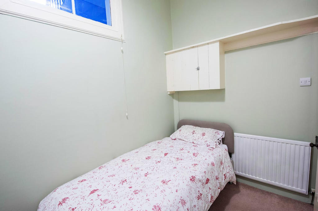 Single bedroom with window facing into stairwell.