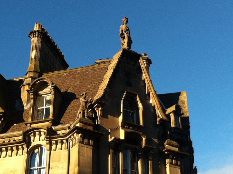 A statue of Queen Victoria perches high on the roof of the building