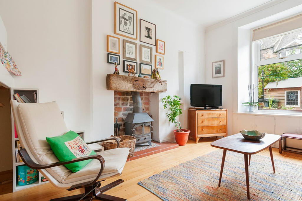 Art filled living room with wood burning stove and view into private garden