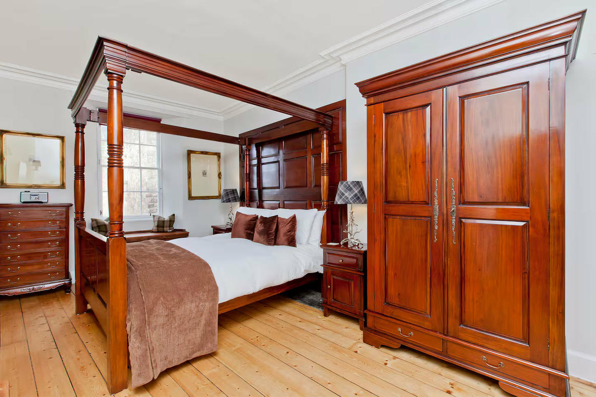 Luxury master bedroom with four poster king sized bed and digital radio.